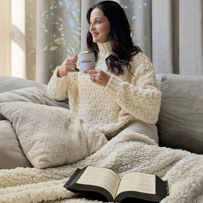 Mulher tomando CAPPUCCINOFIT enquanto lê no sofá